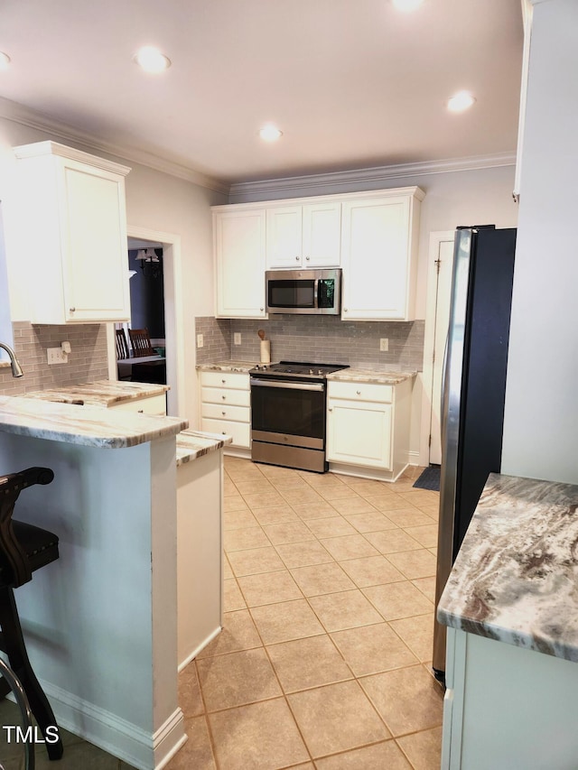 155 Georgetown Woods Dr, Youngsville, NC 27596 - kitchen with white cabinets, stainless steel appliances, ornamental molding, and decorative backsplash