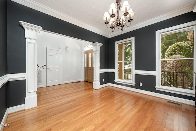 155 Georgetown Woods Dr, Youngsville, NC 27596 - unfurnished room featuring decorative columns, light wood-style floors, a chandelier, and crown molding