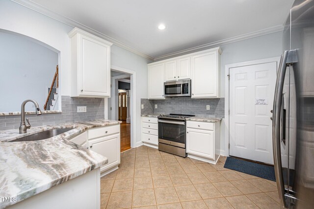 155 Georgetown Woods Dr, Youngsville, NC 27596 - kitchen with appliances with stainless steel finishes, backsplash, ornamental molding, white cabinets, and light stone countertops