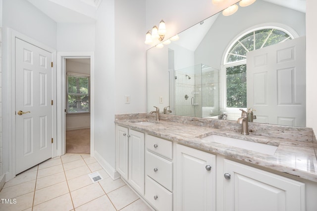 155 Georgetown Woods Dr, Youngsville, NC 27596 - full bathroom featuring a tile shower, double vanity, tile patterned flooring, and lofted ceiling