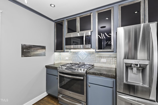 kitchen featuring stainless steel appliances, baseboards, decorative backsplash, dark wood finished floors, and glass insert cabinets