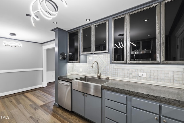 kitchen featuring dark wood-type flooring, gray cabinets, dishwasher, and a sink