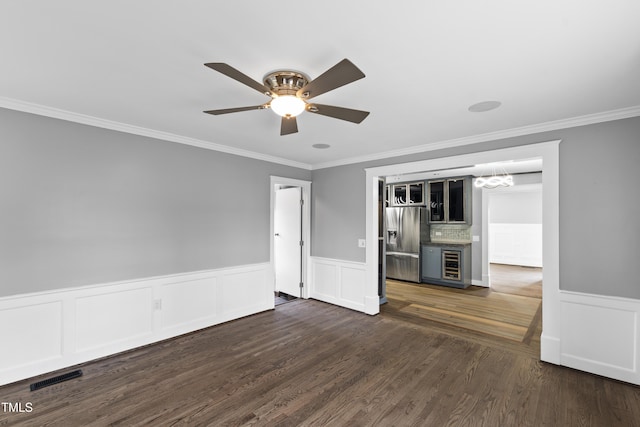 spare room featuring wine cooler, visible vents, dark wood finished floors, and ceiling fan