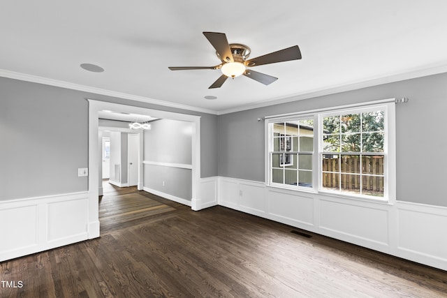 spare room featuring a wainscoted wall, crown molding, visible vents, and wood finished floors