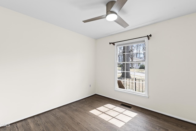 empty room featuring baseboards, visible vents, ceiling fan, and wood finished floors