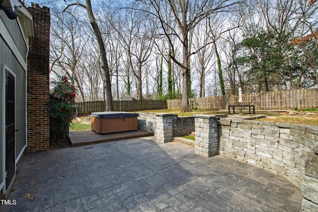 view of patio with a fenced backyard and a hot tub