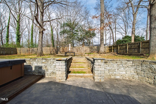 view of patio featuring a hot tub and a fenced backyard