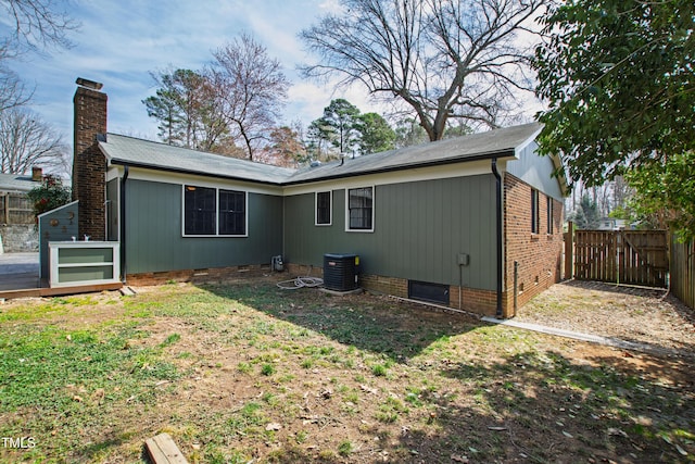 rear view of house with crawl space, a chimney, a fenced backyard, and central air condition unit