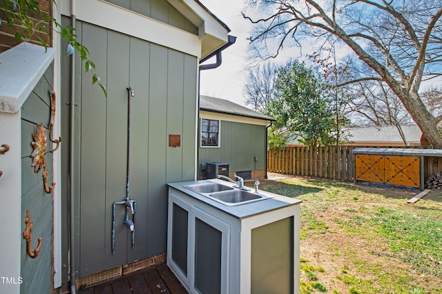 view of outdoor structure with fence and central AC