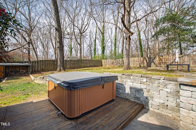 wooden deck with a fenced backyard and a hot tub