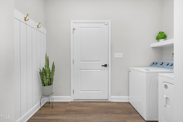 laundry area with laundry area, wood finished floors, washing machine and clothes dryer, and baseboards