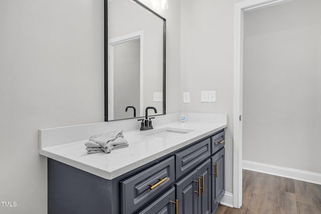 bathroom featuring vanity, baseboards, and wood finished floors