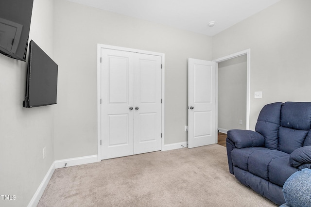 living area with baseboards and light colored carpet