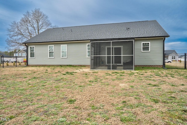 rear view of property with a sunroom, a lawn, and fence