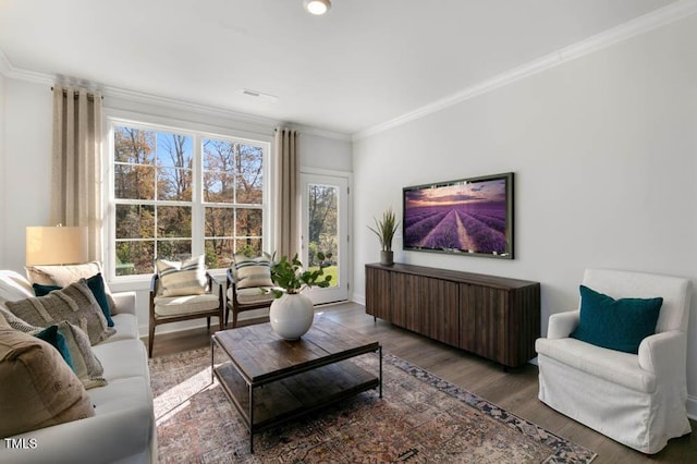 living room with baseboards, visible vents, ornamental molding, and wood finished floors