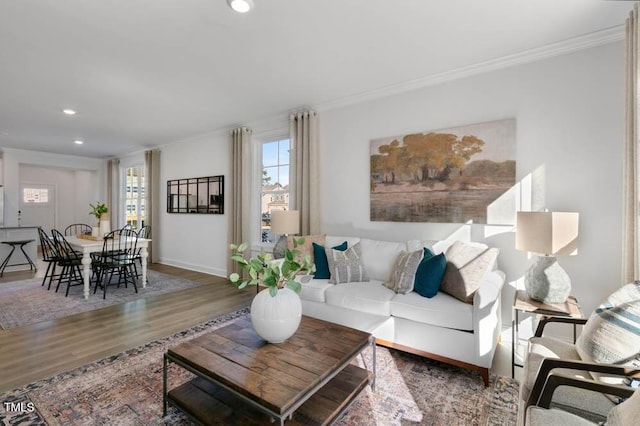 living room featuring baseboards, recessed lighting, wood finished floors, and crown molding