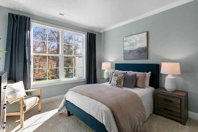 carpeted bedroom with baseboards, visible vents, and crown molding