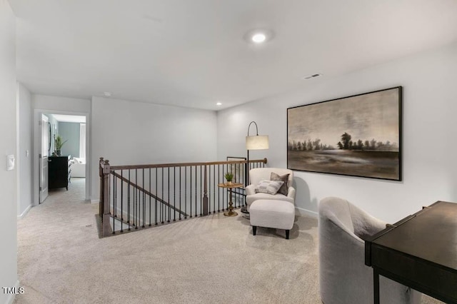 sitting room featuring recessed lighting, carpet, baseboards, and an upstairs landing