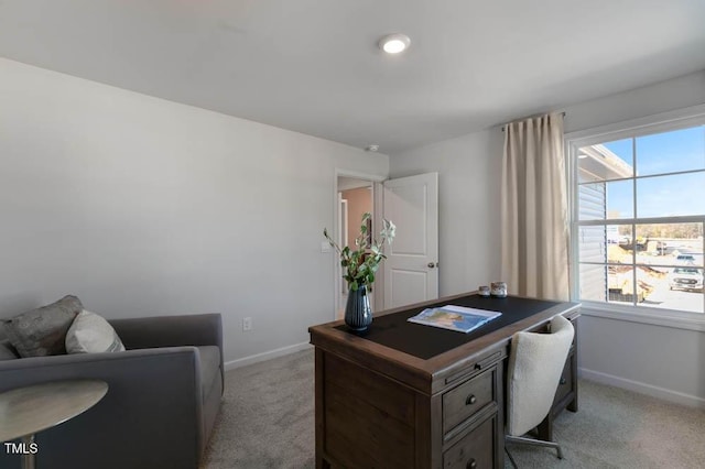 home office featuring light carpet, plenty of natural light, and baseboards