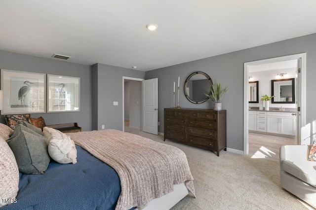 bedroom featuring light colored carpet, visible vents, connected bathroom, and baseboards