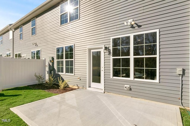 rear view of property featuring a patio, a yard, and fence