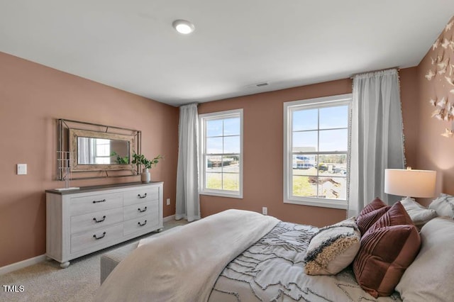 bedroom featuring light carpet and baseboards