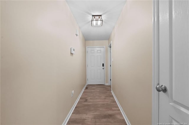 hallway with baseboards and wood finished floors