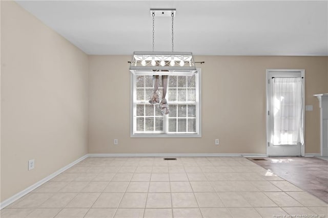 unfurnished room with baseboards, light tile patterned floors, visible vents, and a healthy amount of sunlight