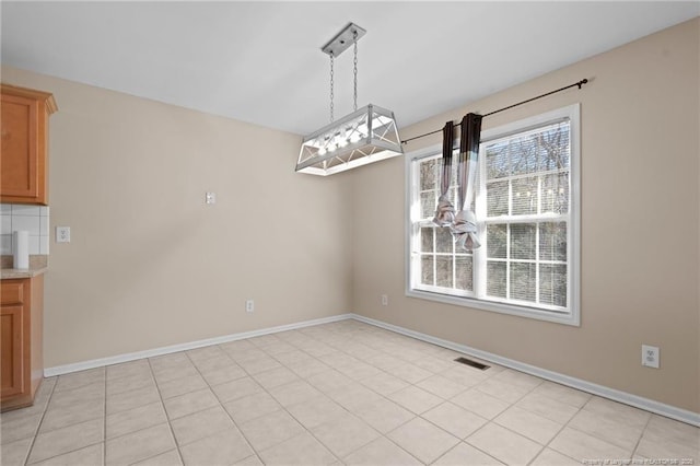 unfurnished dining area featuring light tile patterned floors, baseboards, and visible vents