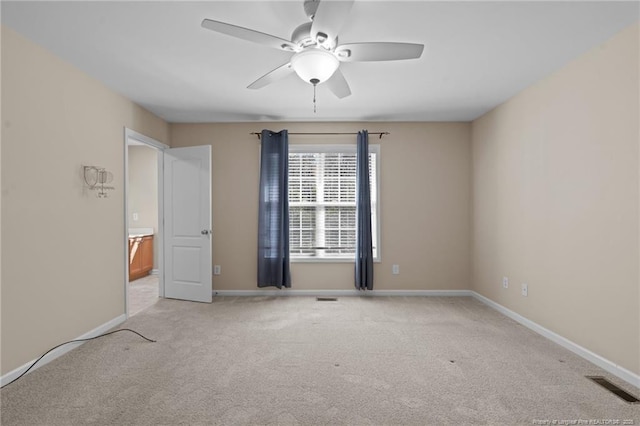 unfurnished room featuring light carpet, ceiling fan, visible vents, and baseboards