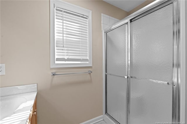 bathroom with vanity, baseboards, and a shower with shower door