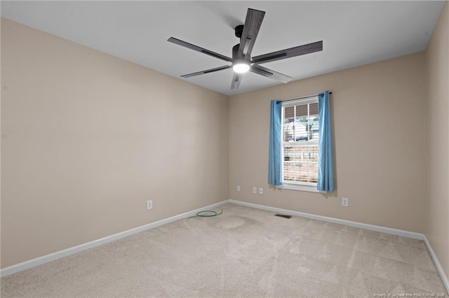 spare room featuring ceiling fan, visible vents, baseboards, and light colored carpet