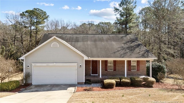 single story home featuring covered porch, driveway, brick siding, and an attached garage