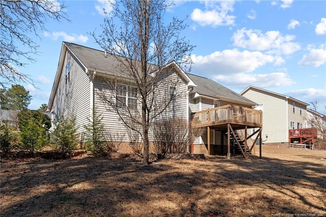 back of property featuring stairs and a wooden deck