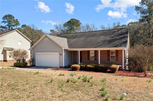 single story home featuring brick siding, a porch, an attached garage, driveway, and a front lawn