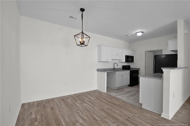 kitchen featuring black appliances, white cabinetry, visible vents, and light wood finished floors