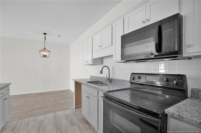 kitchen with black appliances, a sink, white cabinetry, and decorative backsplash