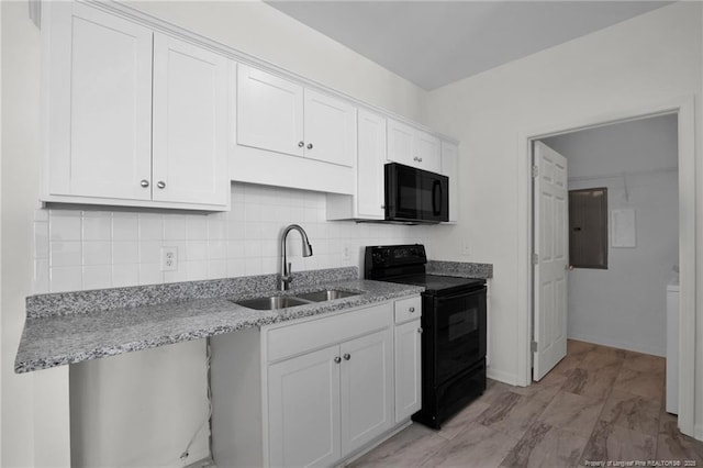 kitchen with light stone counters, backsplash, white cabinets, a sink, and black appliances