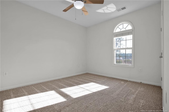 empty room with carpet flooring, visible vents, and baseboards