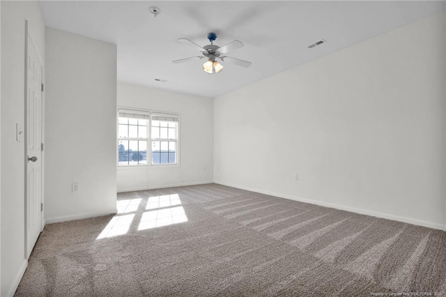 empty room featuring ceiling fan, carpet, visible vents, and baseboards