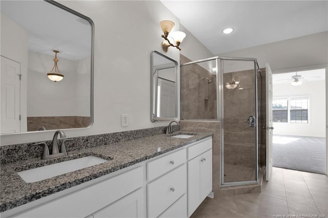 full bath featuring double vanity, recessed lighting, a sink, and a shower stall