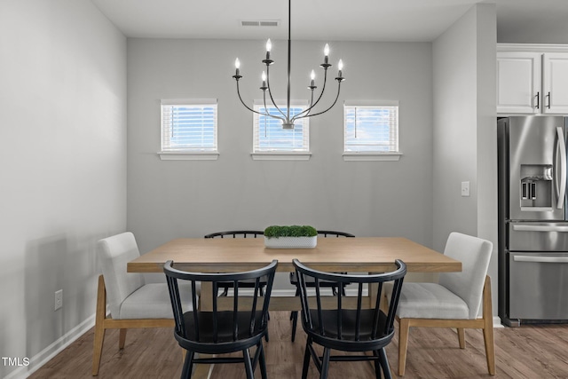 350 Arlie Ln, Lillington, NC 27546 - dining space with healthy amount of natural light, wood finished floors, a chandelier, and baseboards