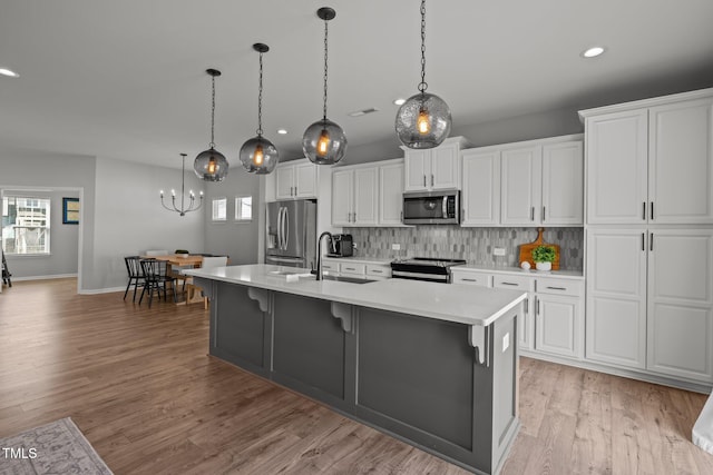 350 Arlie Ln, Lillington, NC 27546 - kitchen featuring stainless steel appliances, a sink, recessed lighting, light countertops, and a center island with sink
