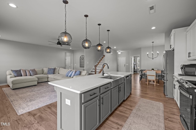 350 Arlie Ln, Lillington, NC 27546 - kitchen featuring a sink, stainless steel appliances, white cabinets, an island with sink, and light countertops