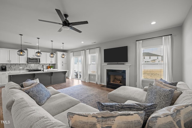 350 Arlie Ln, Lillington, NC 27546 - living room with recessed lighting, ceiling fan, light wood-style floors, a fireplace with flush hearth, and baseboards