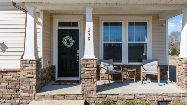 property entrance featuring stone siding and a porch