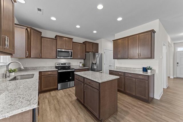 kitchen featuring light wood finished floors, visible vents, appliances with stainless steel finishes, and a sink