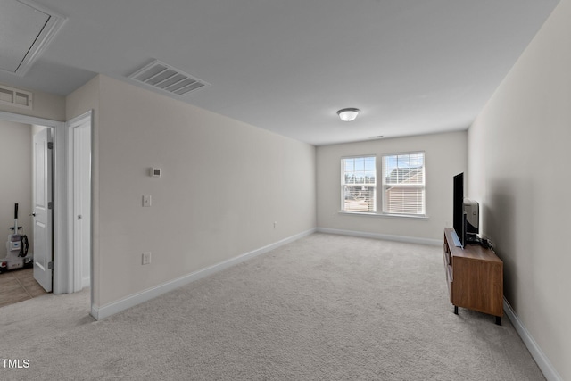 living area with attic access, visible vents, and light carpet