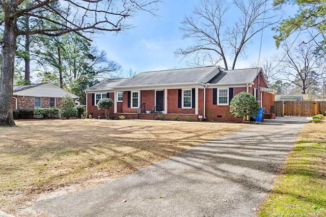 ranch-style home with crawl space, fence, aphalt driveway, and brick siding