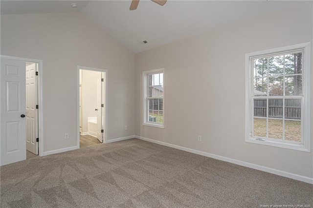 unfurnished bedroom with lofted ceiling, ensuite bathroom, visible vents, baseboards, and carpet